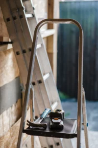 escabeau avec des outils et une échelle en arrière plan