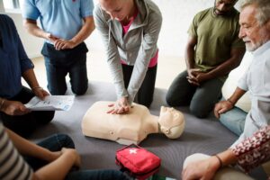 formation aux premiers secours plusieurs personnes regardent un massage cardiaque sur un mannequin