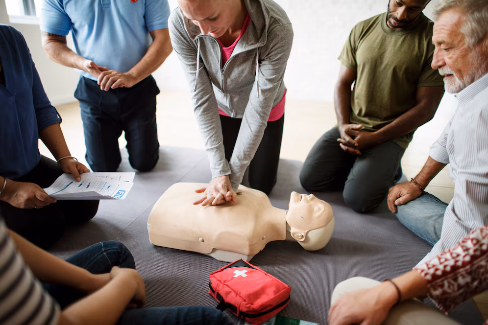 formation aux premiers secours plusieurs personnes regardent un massage cardiaque sur un mannequin
